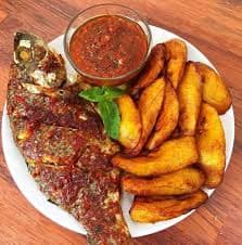 Plantain with tilapia and sauce served on a plate